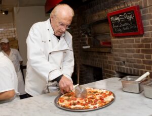 Patsy Grimaldi slices a pizza