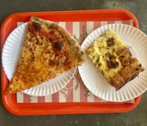two slices of pizza on an orange cafeteria tray